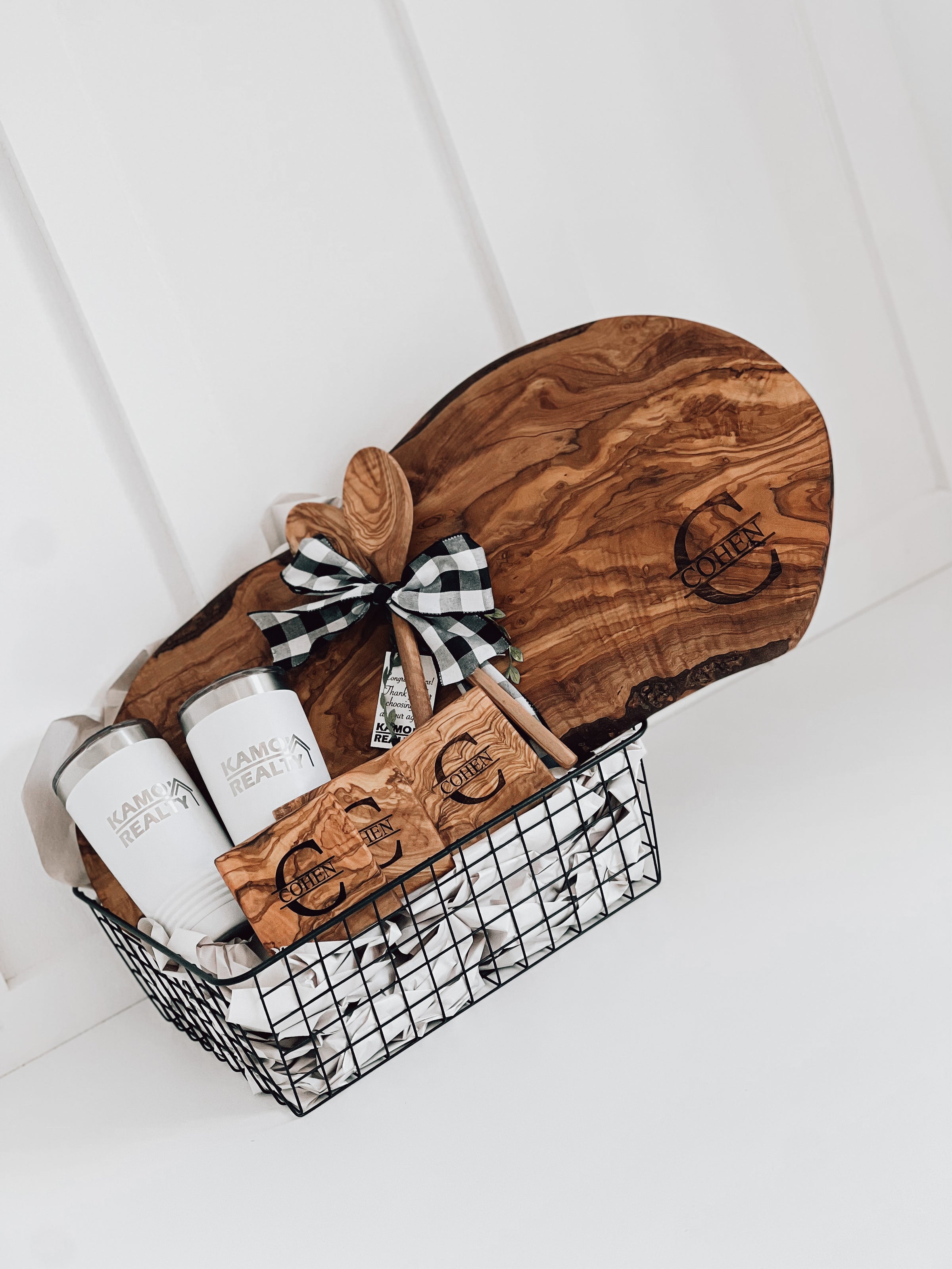 Real estate gift basket of olivewood board and coasters with last name monogram personal logo tumblers and two wooden spoons
