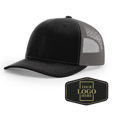 Realtor branded black and charcoal trucker snapback hat with a black hex patch with gold engraving