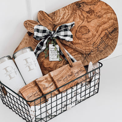 Real estate gift of a large olive wood gift basket including a large olive wood board and matching coasters with design 1 and 2 20 oz tumblers with design 2 on them 
