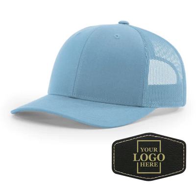 Realtor branded light blue trucker snapback hat with a black hex patch with gold engraving