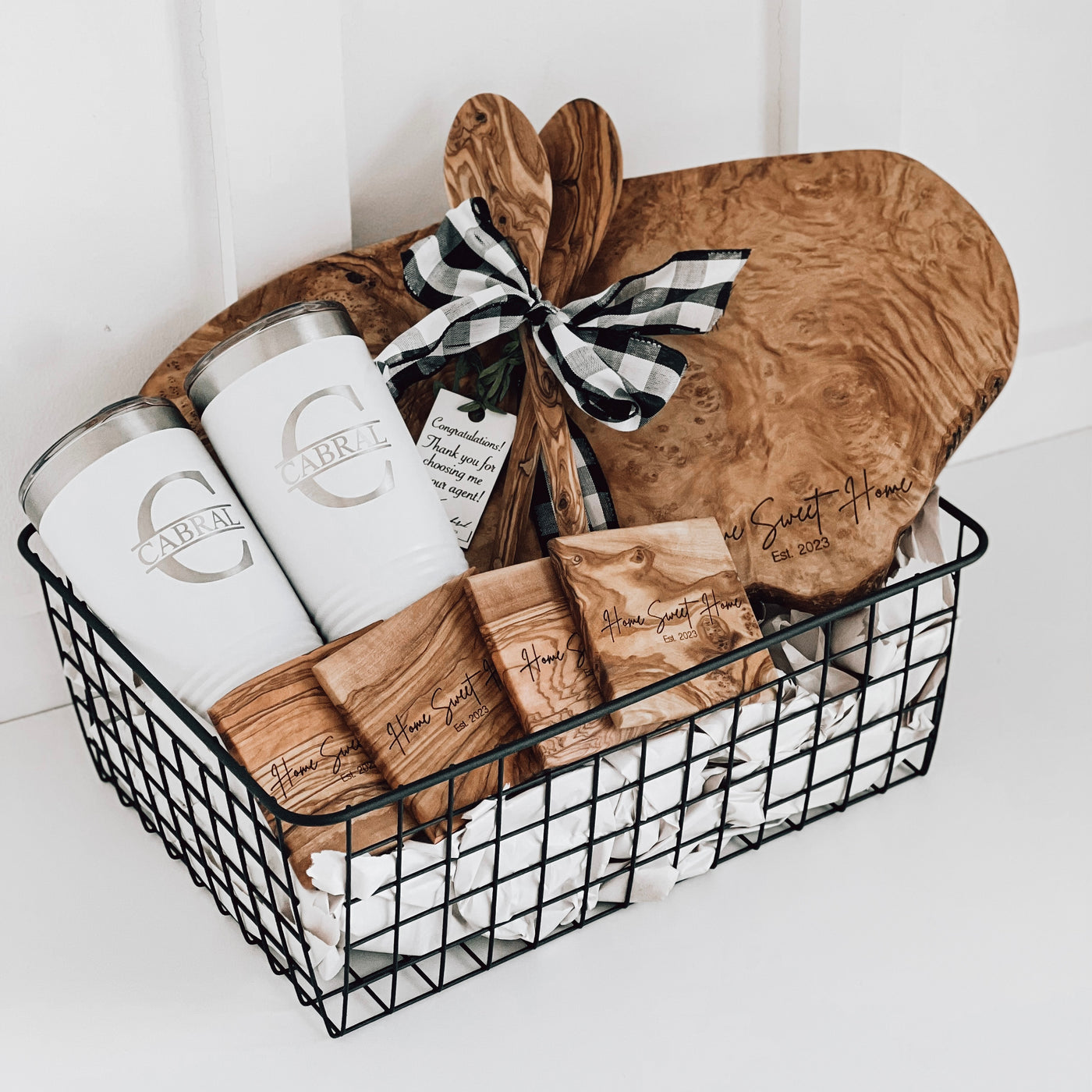 Real estate closing gift of small olivewood gift basket includes olivewood board and coasters with design 1, tumblers, and two spoons