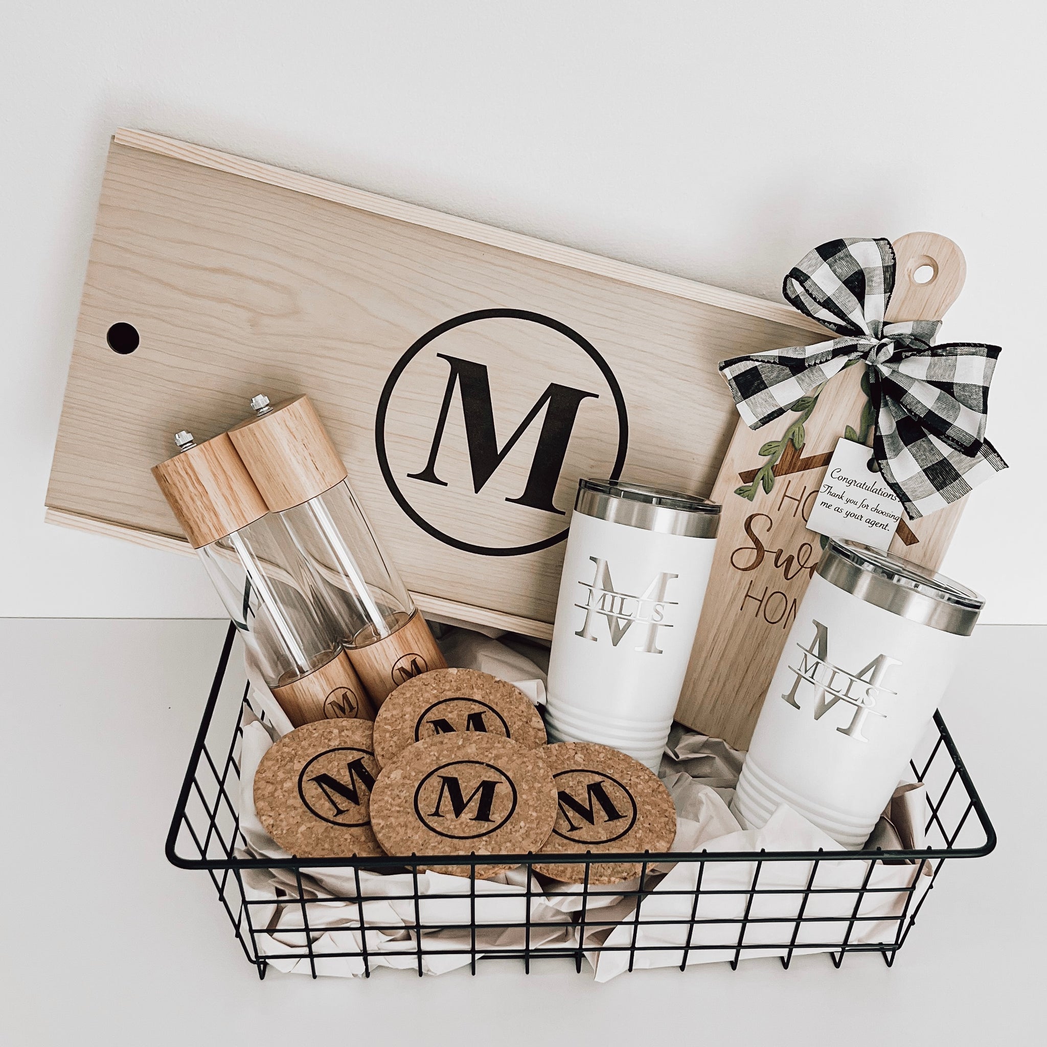 Real estate gift of grill basket that includes salt and pepper shakers, cork coasters, small rubber wood board, and 2 20 oz tumblers