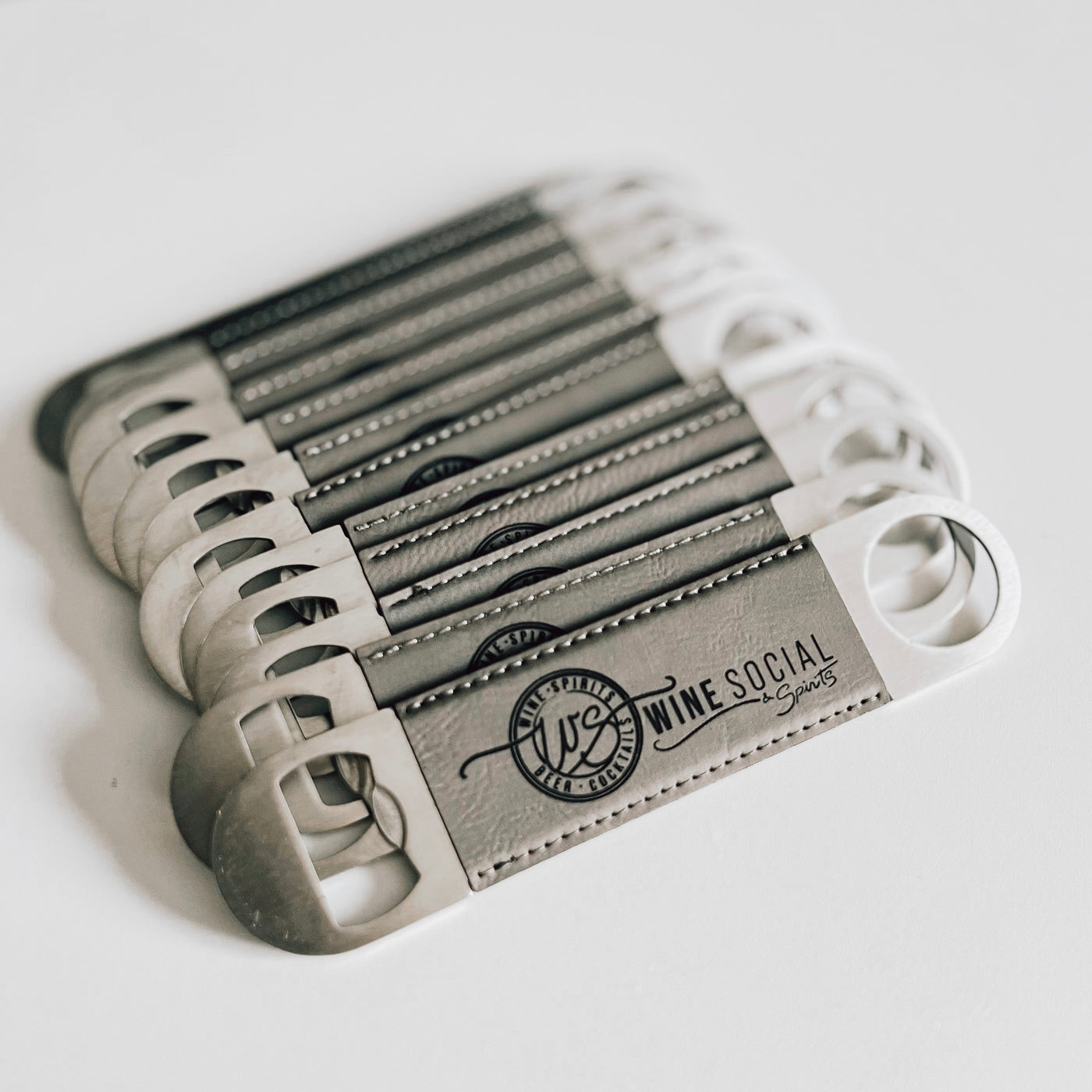 Real estate gift of bulk branded leatherette bottle opener in gray with black engraving