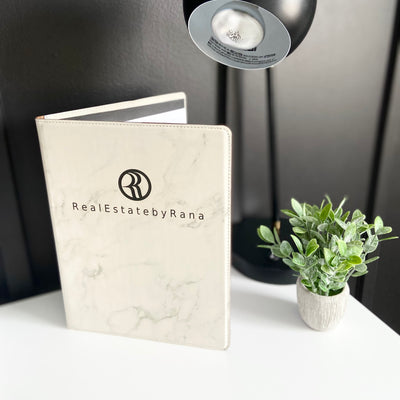 Real estate promotional gift of a marble leatherette portfolio with notepad engraved with black 