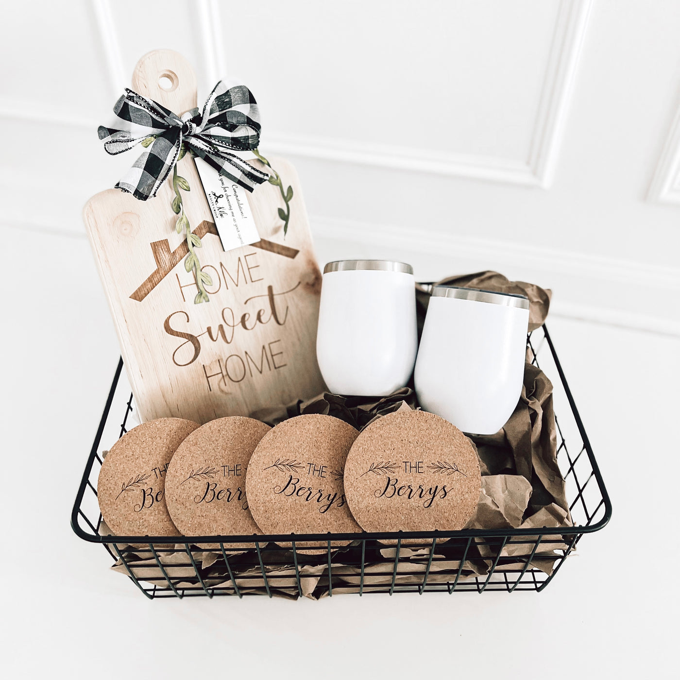 Real estate closing gift rubber wood basket 2 which includes a medium rubber wood cutting board, cork coasters, and 2 12 oz wine tumblers