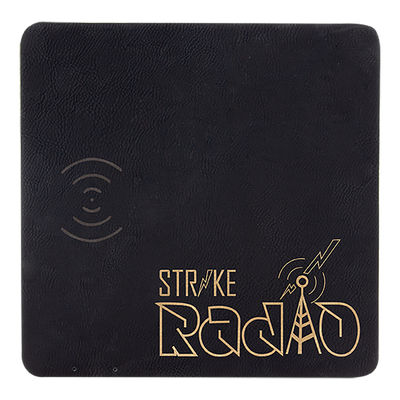 Real estate promotional gift of a black branded leatherette wireless charging mat engraved in gold